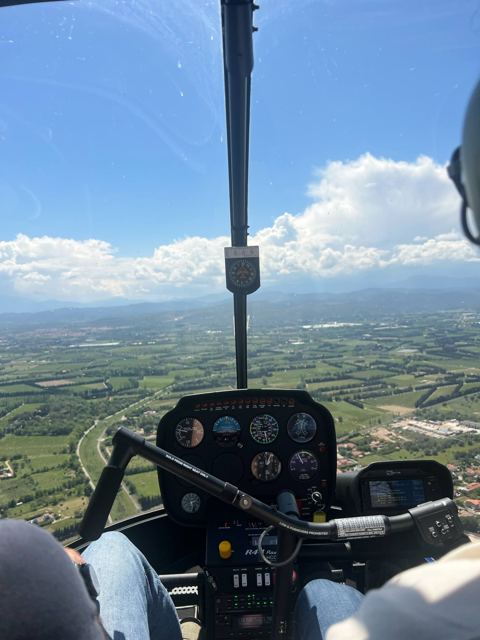 Vue depuis cockpit d'hélicoptère, champs et routes.