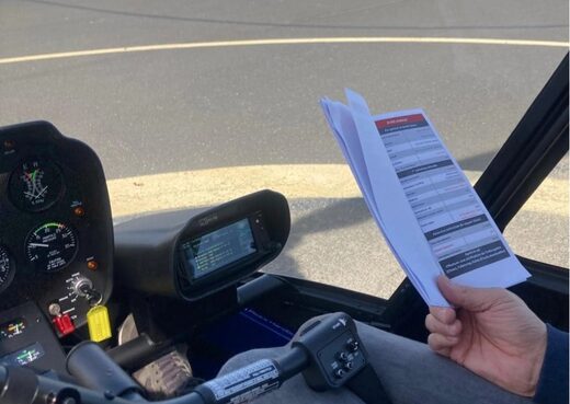 Dans un cockpit, un pilote consulte une checklist imprimée.