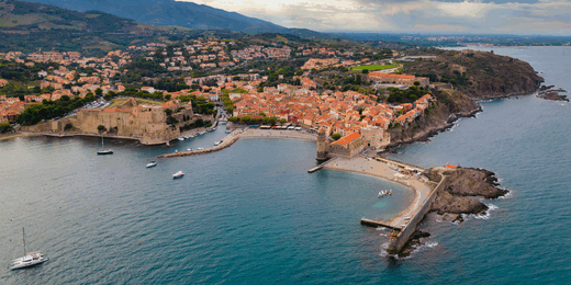 Vue aérienne d'une ville côtière, collines et mer.